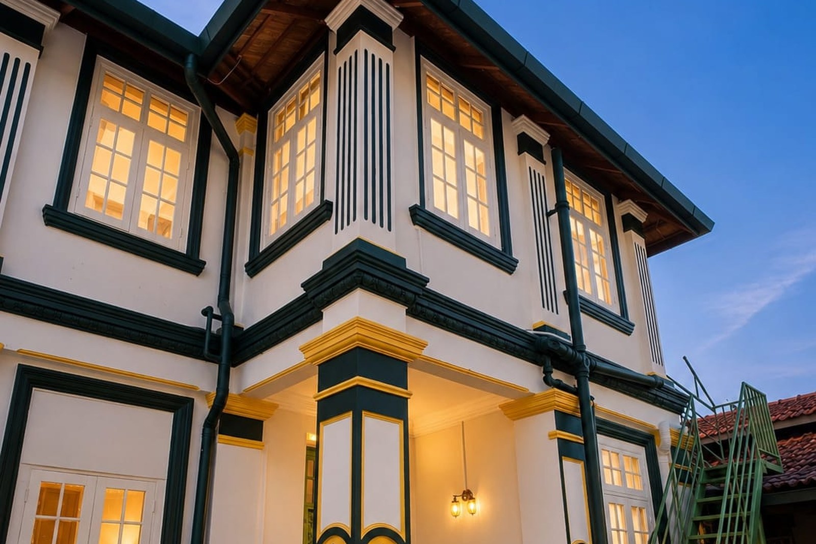 Heritage corner facade of Arvena Living lit up at dusk