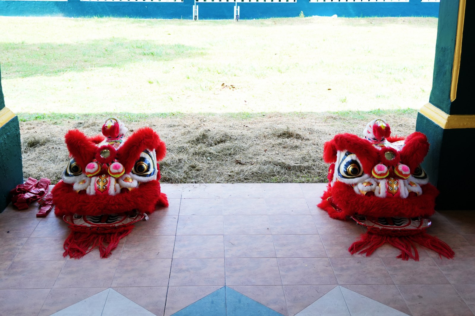 Traditional lion dance heads on the veranda, with the open field visible beyond