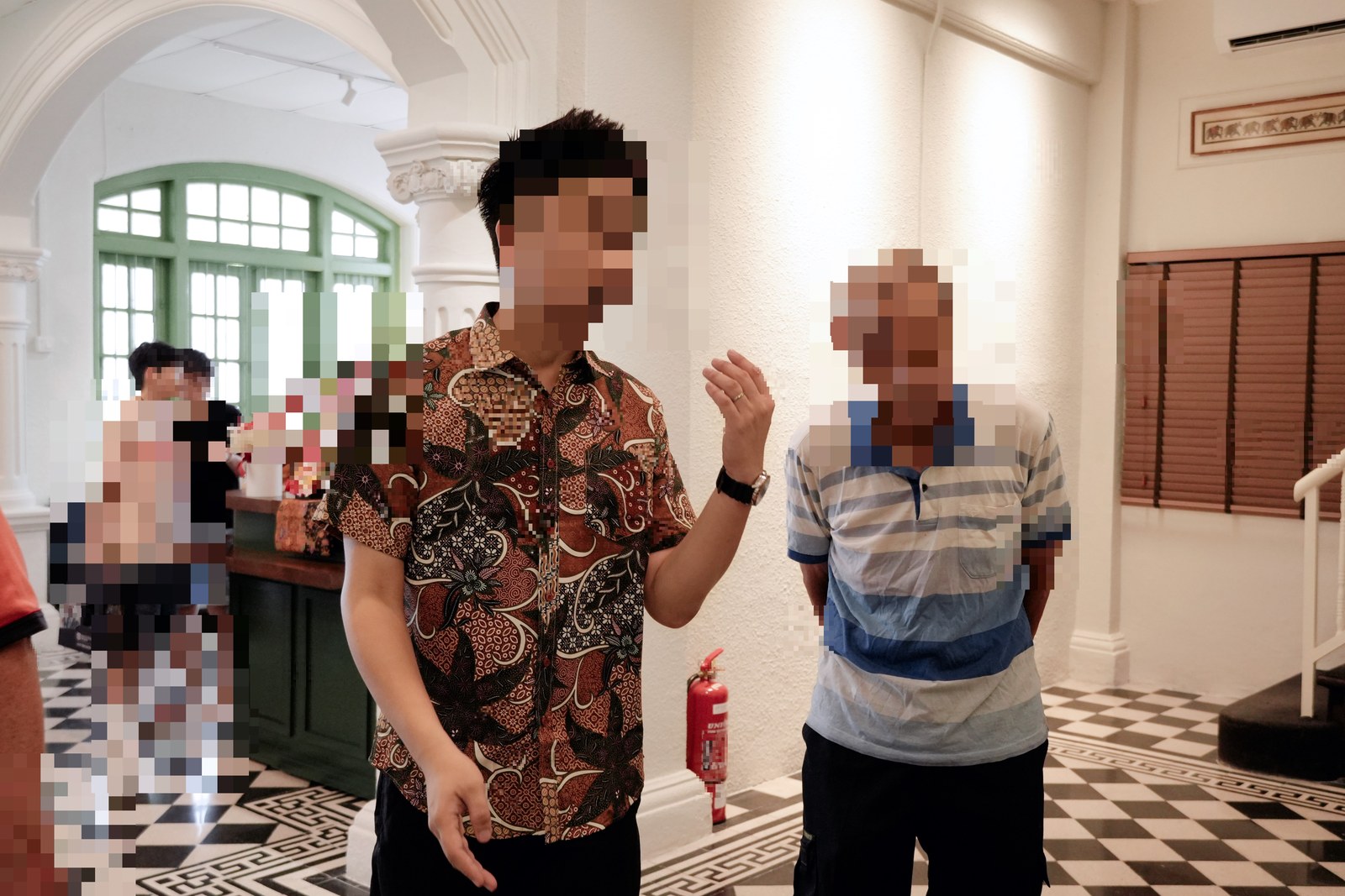 Hosts greeting a guest inside the heritage hall