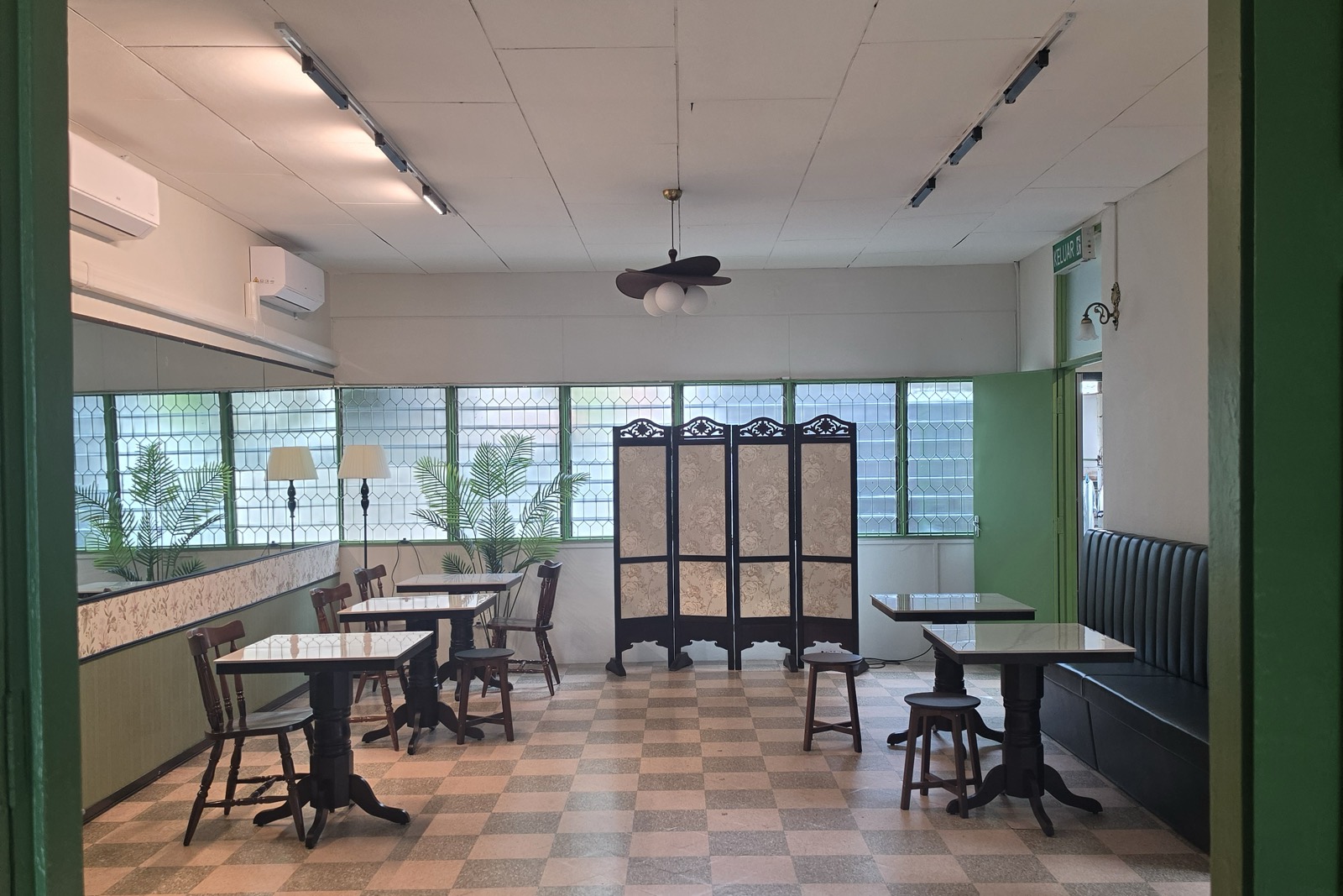 Shared dining hall framed by a green doorway at Arvena Living